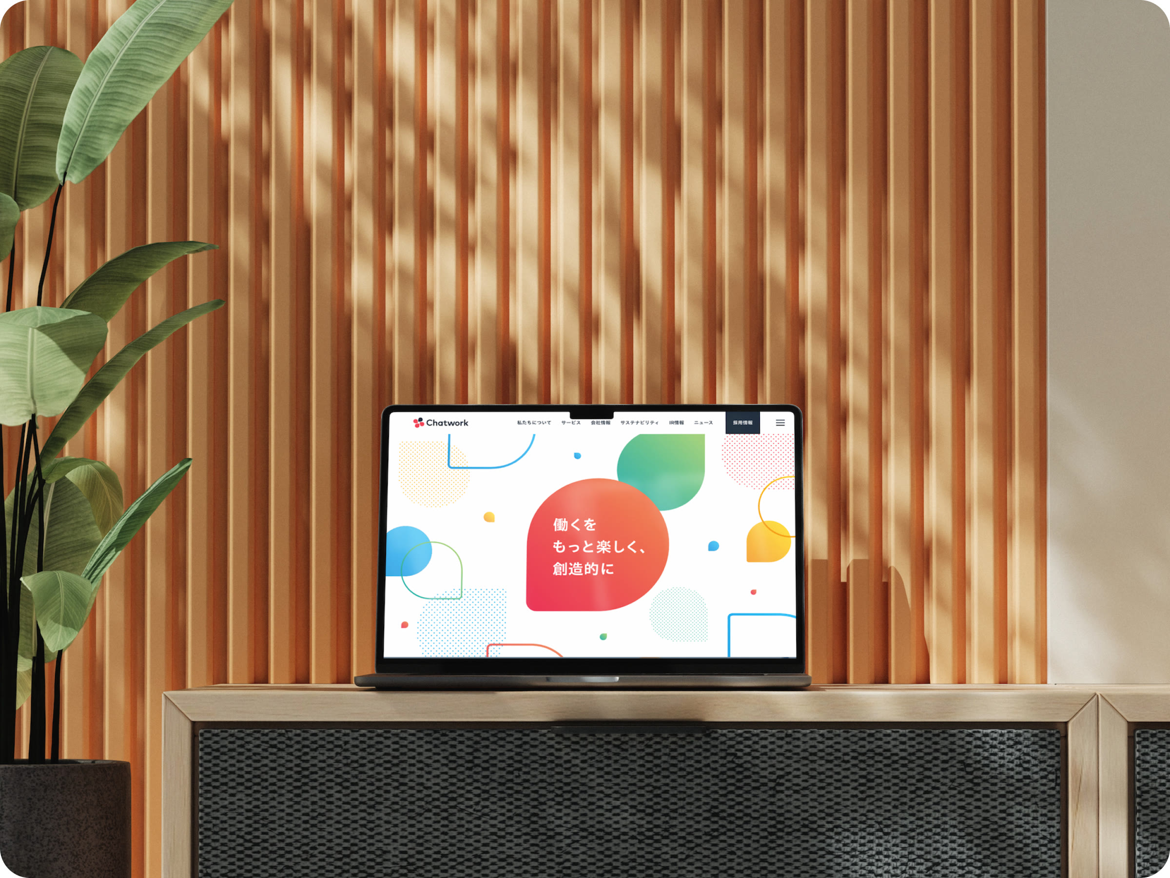 ノートパソコンに表示したChatworkのコーポレートサイトのトップページ。新しいVIの色と形で構成している。